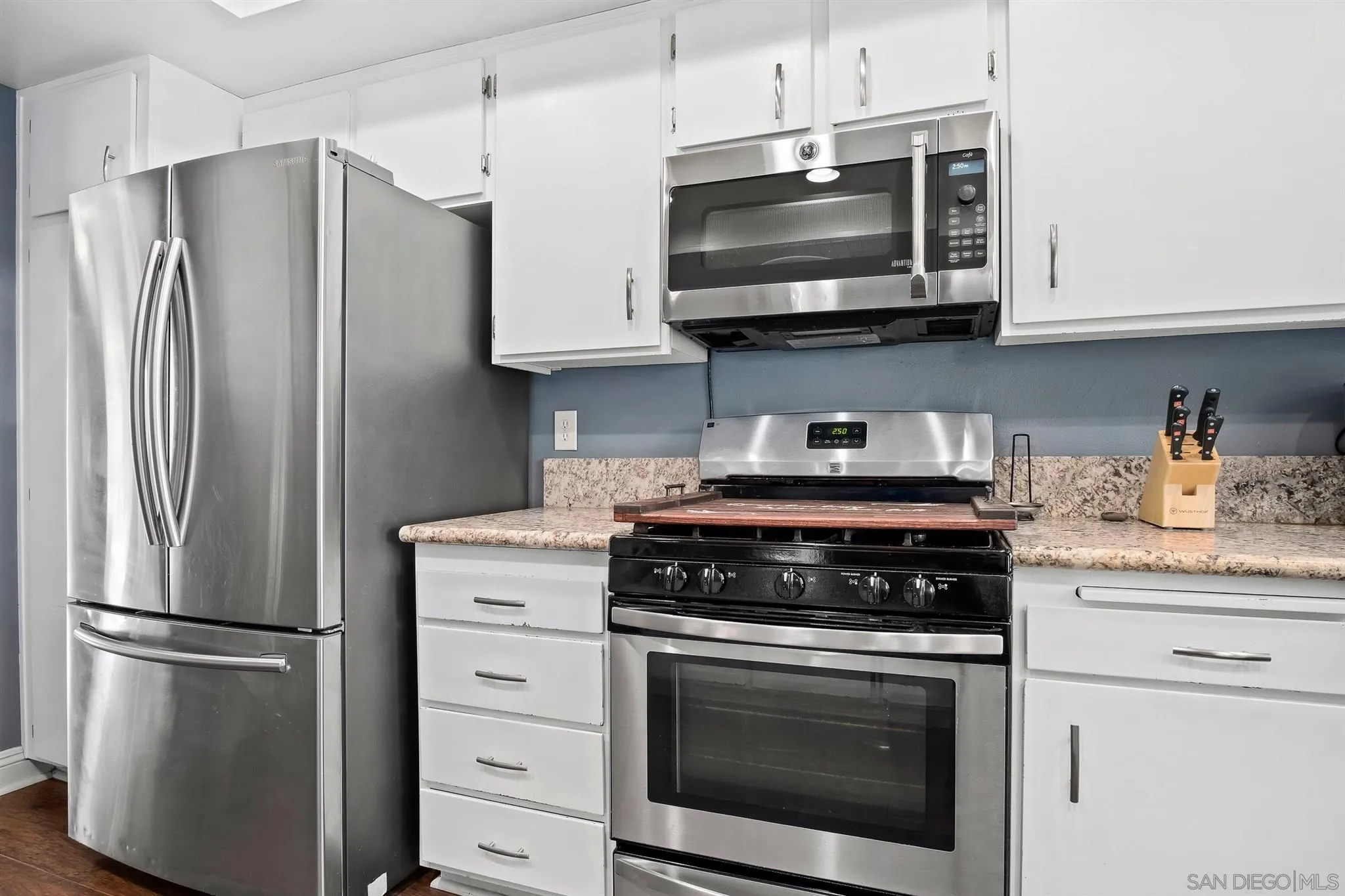 330 Rock Ridge Place Escondido, CA 92027 - Photo 9 of 32 a kitchen with stainless steel appliances white cabinets white stove a microwave and a refrigerator