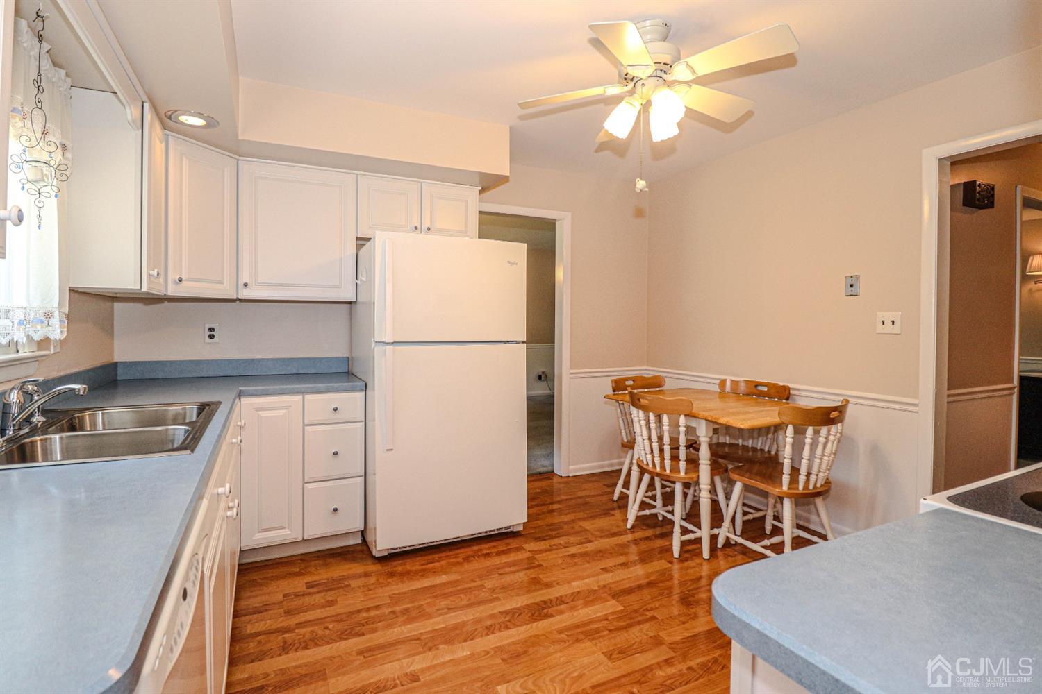 434 Hoffman Station Road Monroe Township, NJ 08831 - Photo 13 of 36 a kitchen with a table chairs refrigerator and cabinets