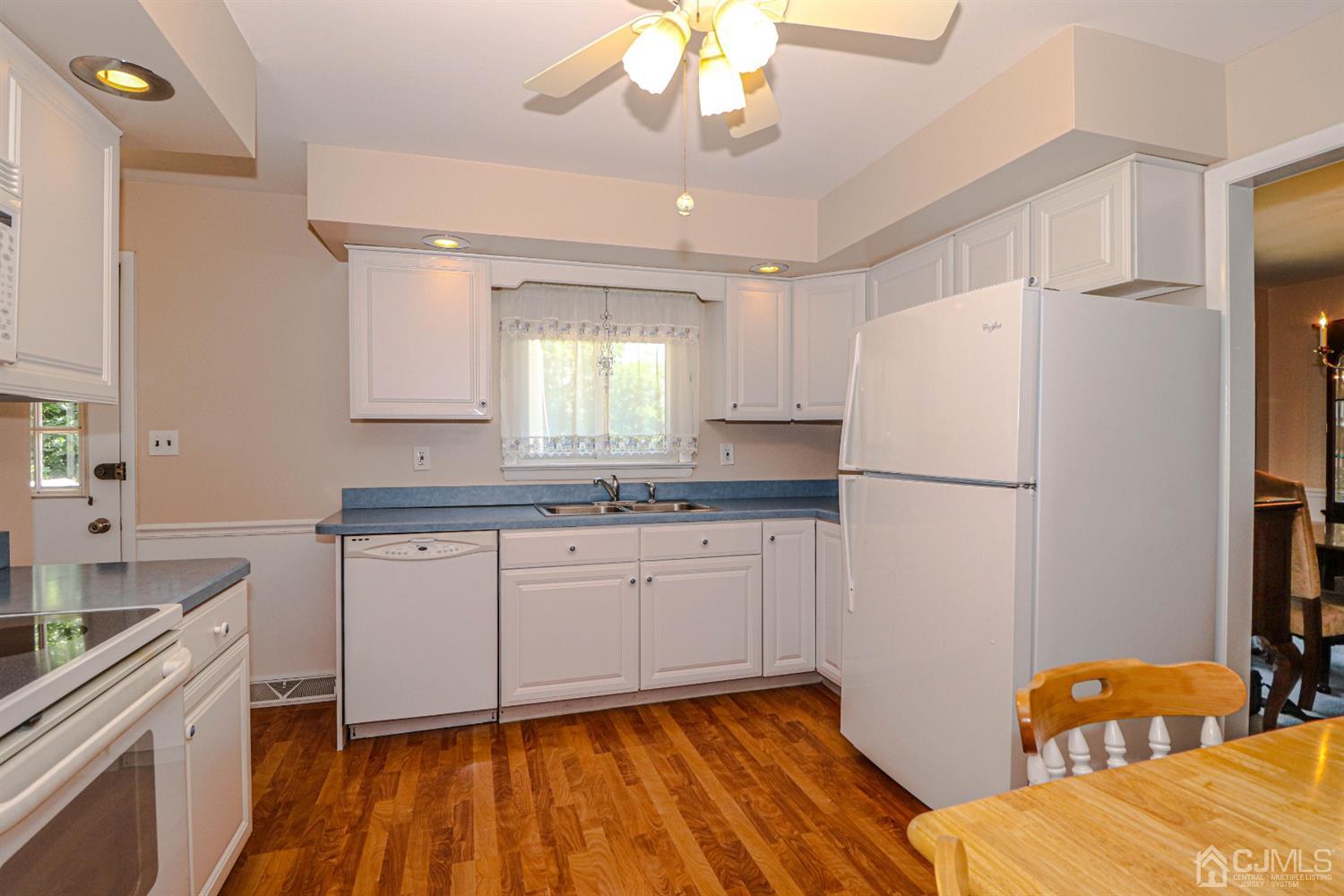 434 Hoffman Station Road Monroe Township, NJ 08831 - Photo 14 of 36 a kitchen with stainless steel appliances granite countertop a refrigerator a sink dishwasher a stove and white cabinets with wooden floor