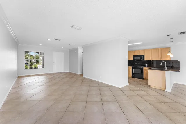 a kitchen with granite countertop a stove a sink and a refrigerator