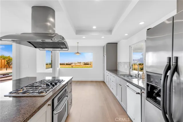 a kitchen with stainless steel appliances granite countertop a stove a sink dishwasher and a refrigerator