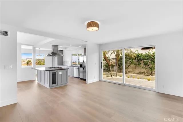 a view of empty room with kitchen and window