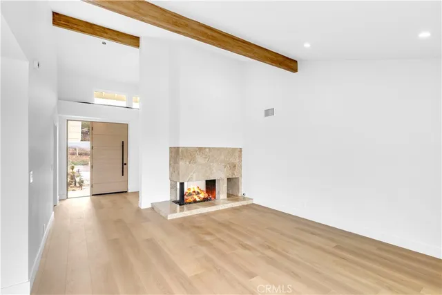 a view of a livingroom with wooden floor and a large window