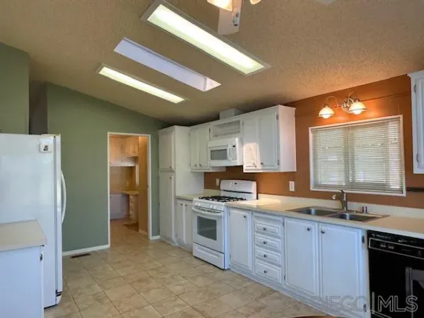 a kitchen with white cabinets and white appliances