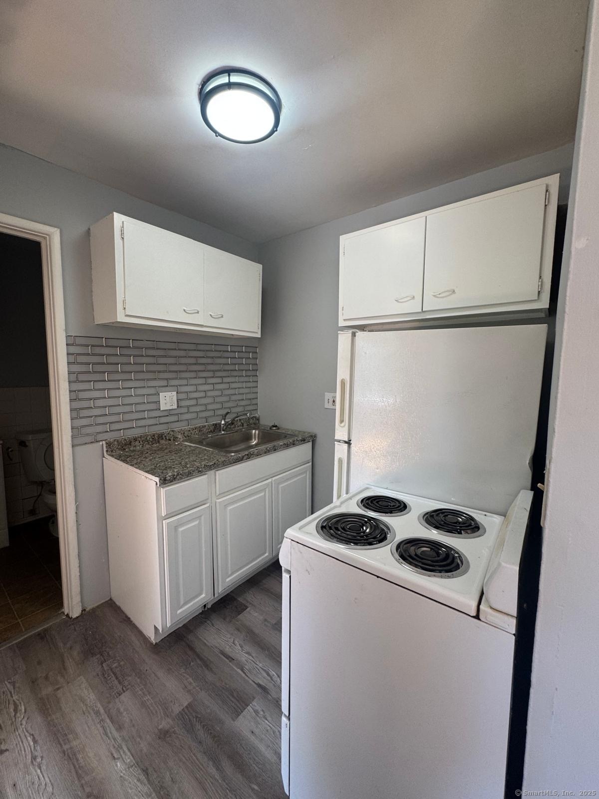 155 Birdseye Street, Unit C7 Bridgeport, CT 06604 - Photo 1 of 7 a kitchen with granite countertop a sink a stove and refrigerator