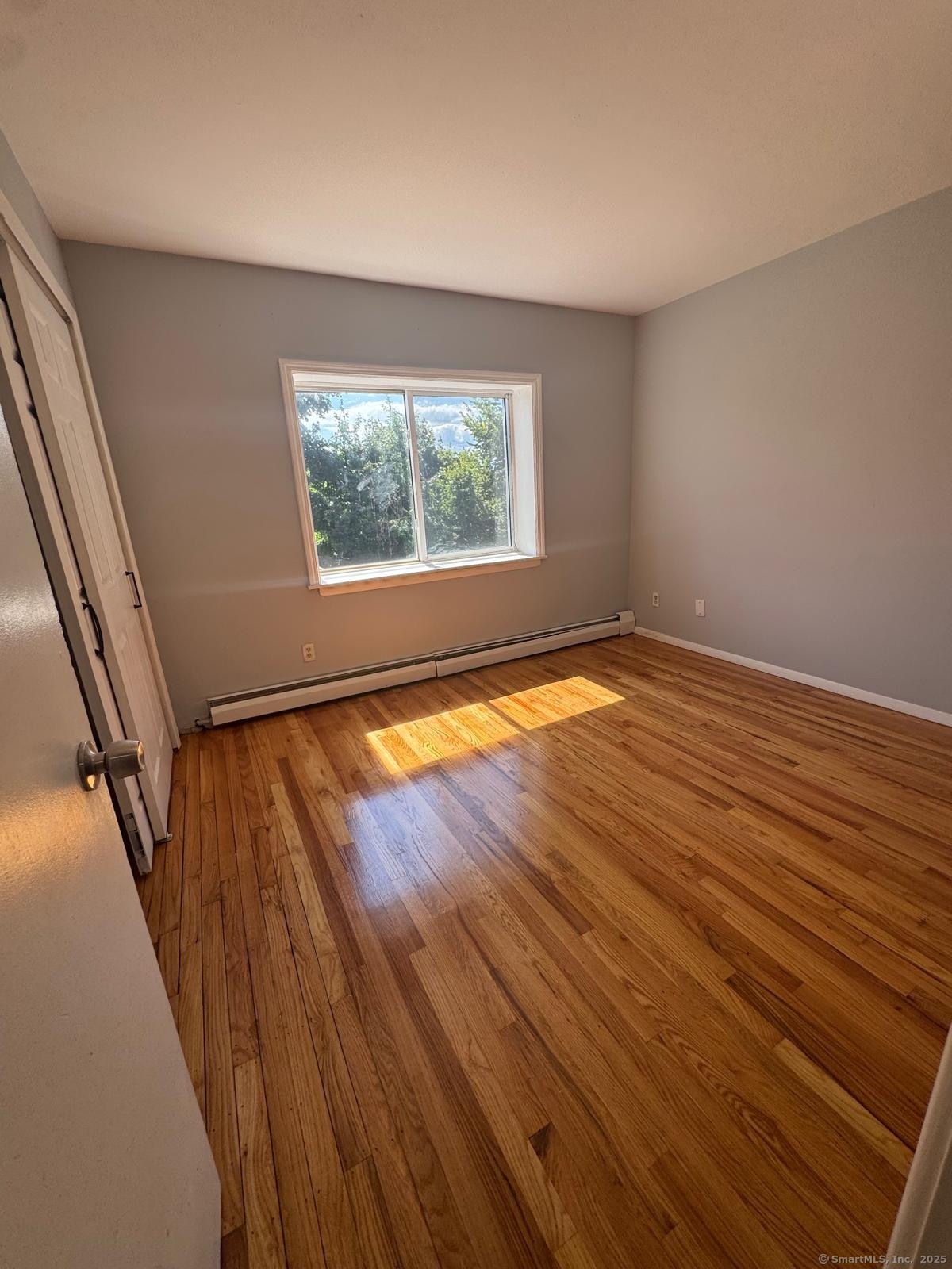 155 Birdseye Street, Unit C7 Bridgeport, CT 06604 - Photo 5 of 7 a view of an empty room with wooden floor and a window