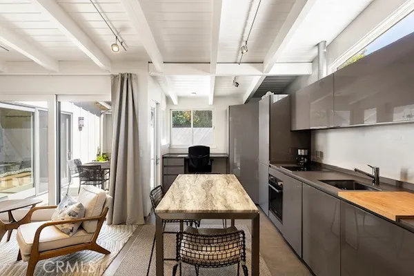 a kitchen with stainless steel appliances granite countertop a stove a refrigerator a sink dishwasher a dining table and chairs with wooden floor