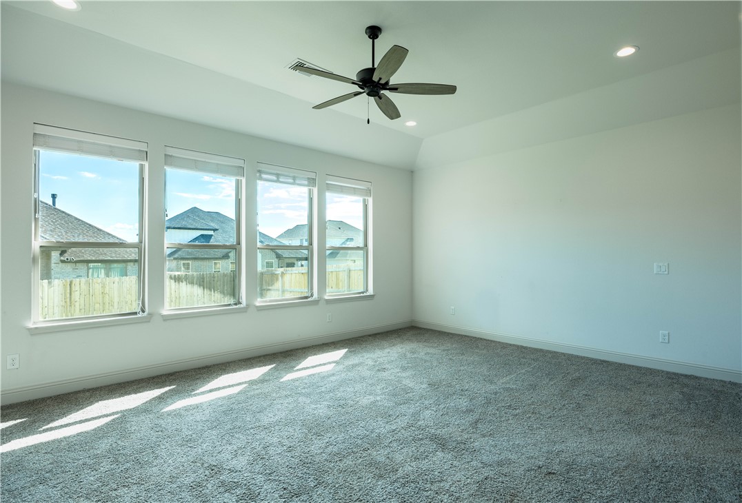 3505 Chantilly Path Bryan, TX 77808 - Photo 7 of 8 Bright Primary Bedroom with plenty of natural light, a tray ceiling, and recessed lighting