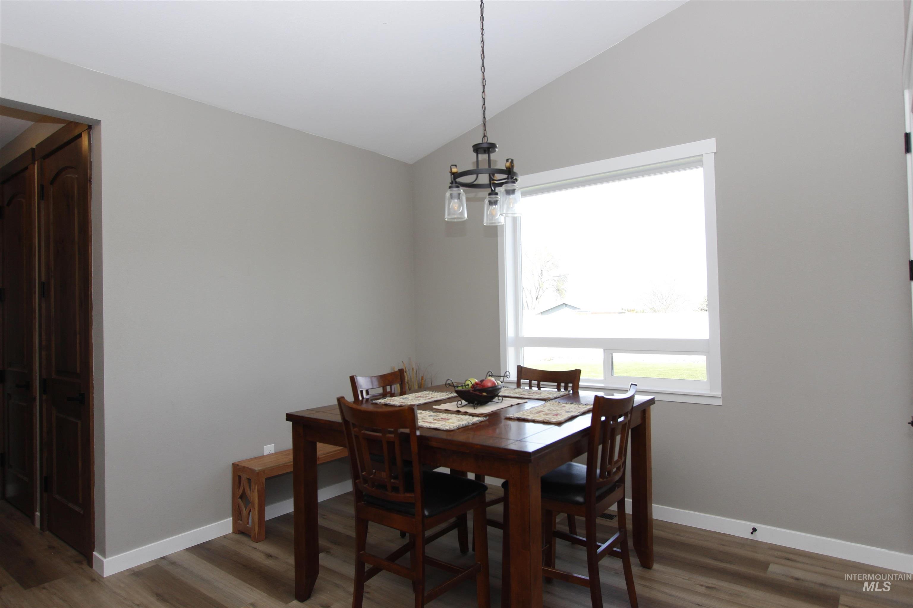 2013 Cedar Avenue Lewiston, ID 83501 - Photo 12 of 46 Dining space featuring vaulted ceiling, wood finished floors, and a chandelier