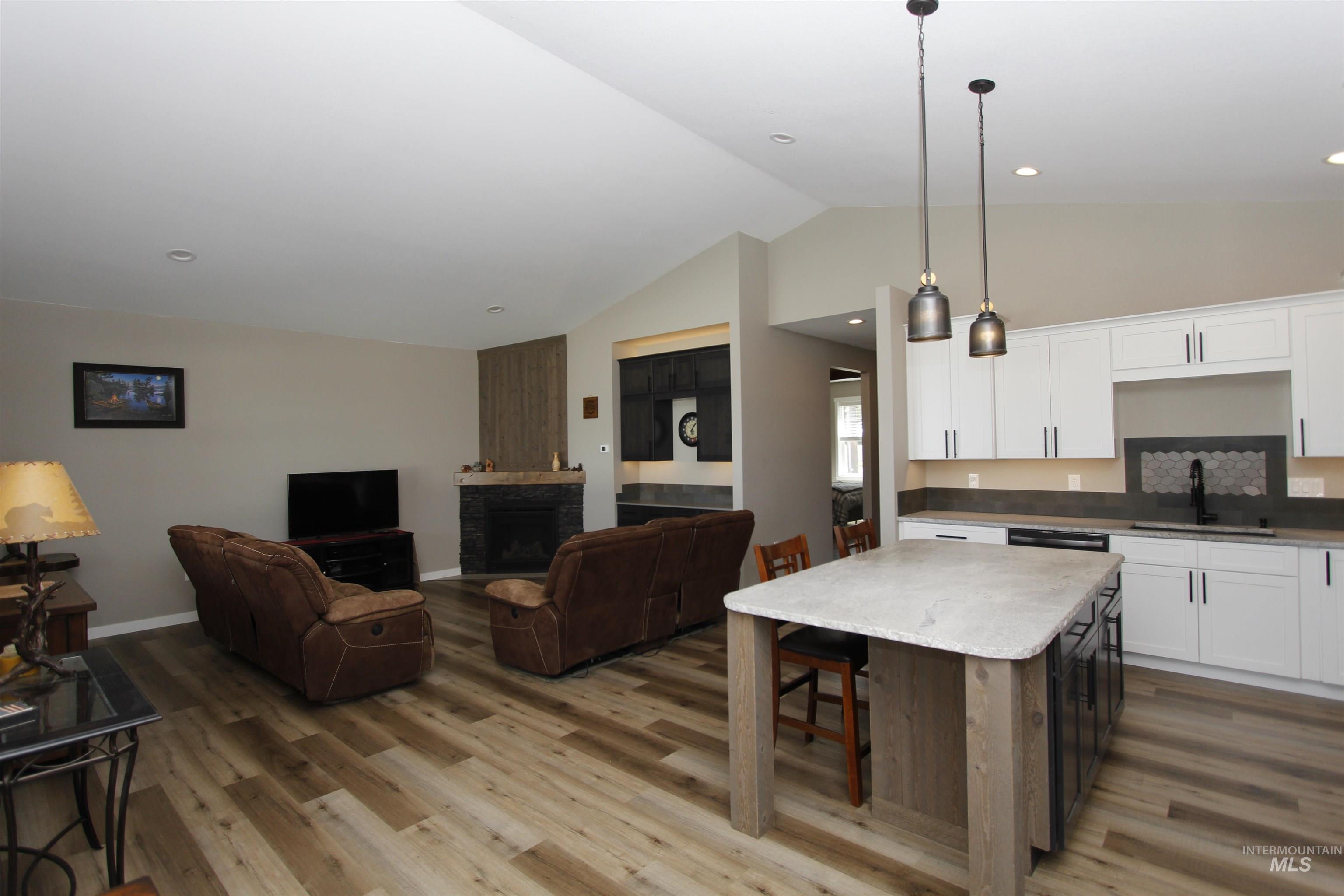 2013 Cedar Avenue Lewiston, ID 83501 - Photo 46 of 46 Kitchen featuring open floor plan, two tone cabinetry, a fireplace, a kitchen bar, and vaulted ceiling