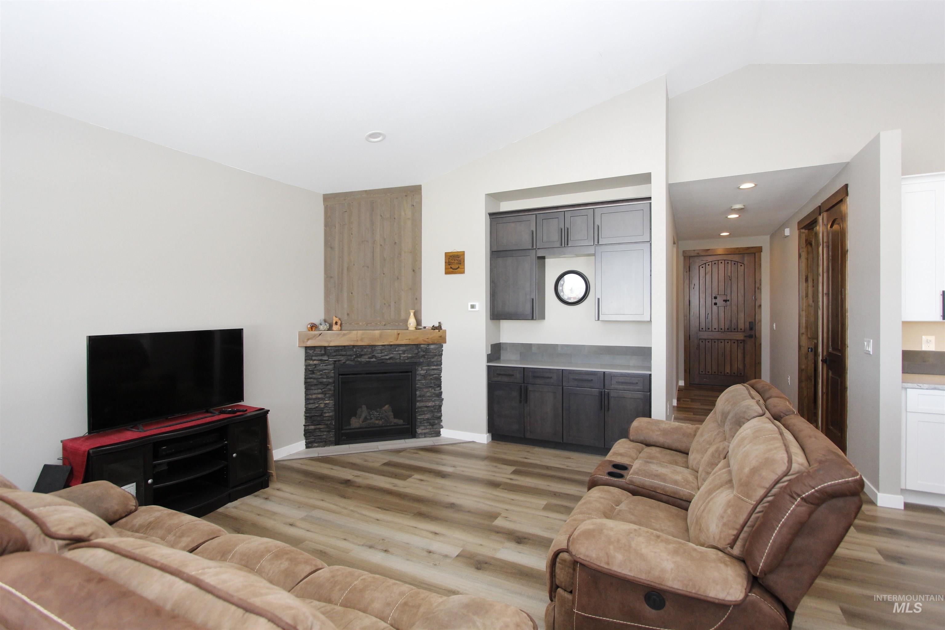 2013 Cedar Avenue Lewiston, ID 83501 - Photo 7 of 46 Living room with light wood-style floors, lofted ceiling, a stone fireplace, and recessed lighting