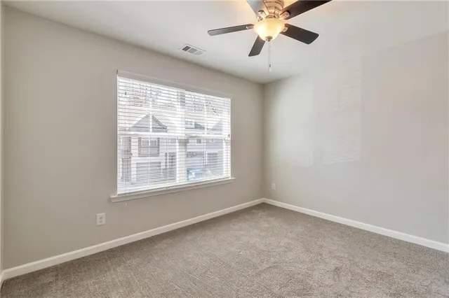 an empty room with a window and a fan