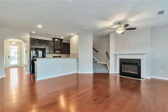 a view of a kitchen with furniture a ceiling fan and a fireplace