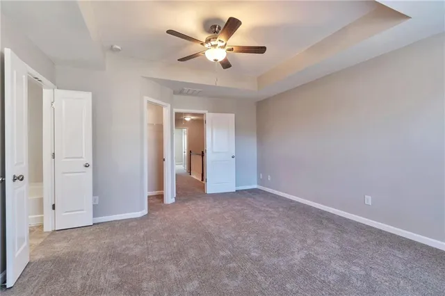 an empty room with closet and a ceiling fan