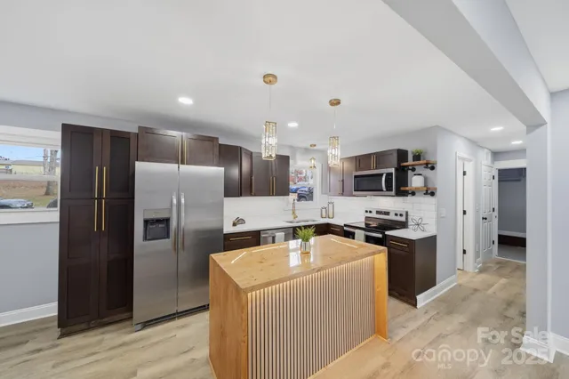 a kitchen with stainless steel appliances refrigerator stove microwave and sink