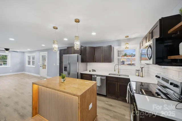 a kitchen with stainless steel appliances kitchen island granite countertop a sink and cabinets