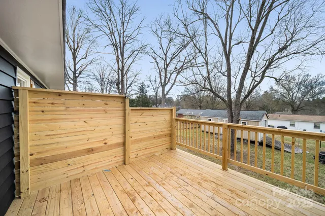 a view of a balcony with wooden fence and trees
