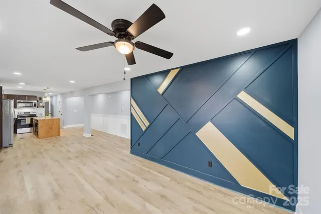 a view of a room with kitchen appliances and a ceiling fan