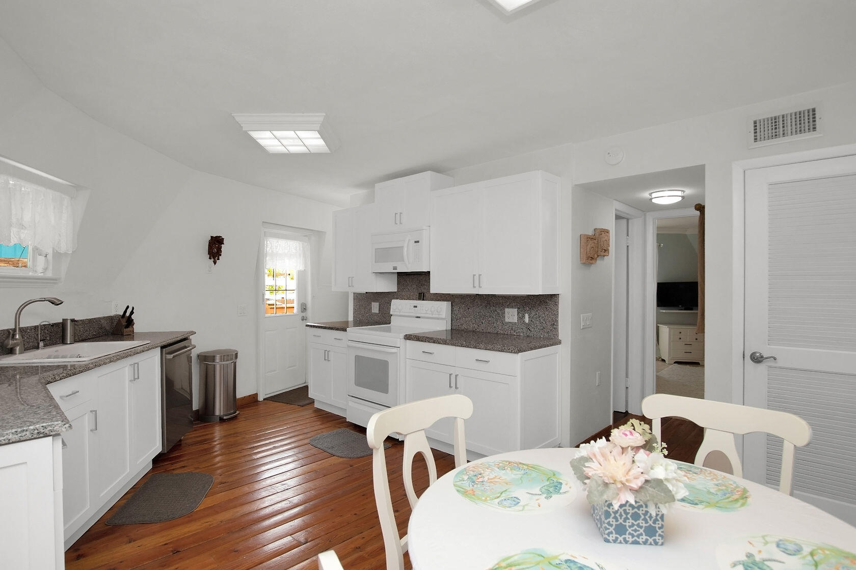 676 Sailfish Trail Key Largo, FL 33037 - Photo 11 of 38 a kitchen with stainless steel appliances granite countertop a kitchen island hardwood floor sink stove dining table and chairs