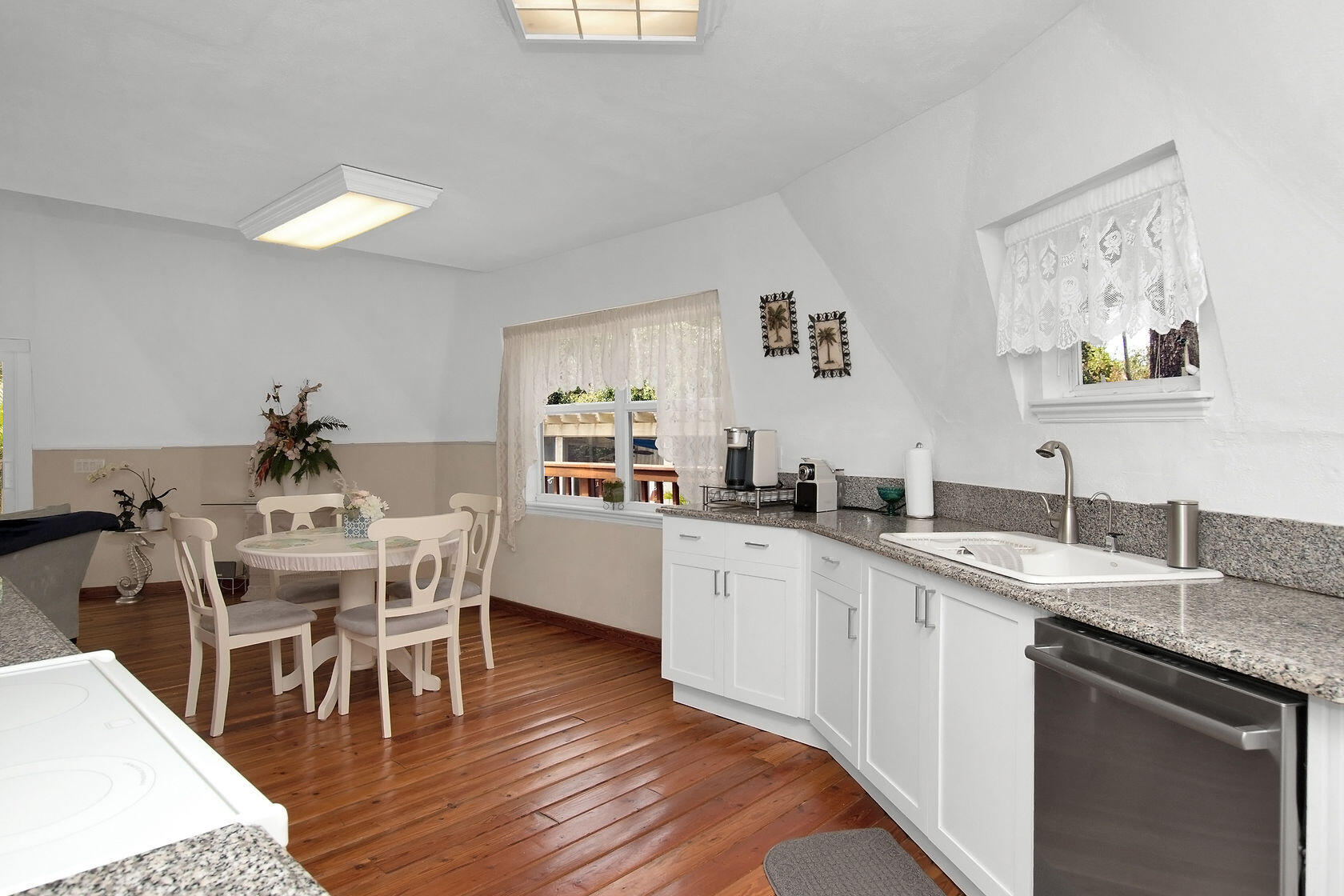 676 Sailfish Trail Key Largo, FL 33037 - Photo 13 of 38 a kitchen with a dining table chairs wooden floor and appliances