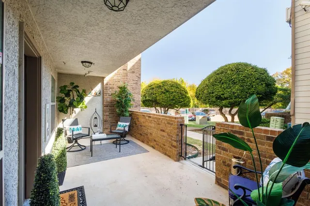 a view of a patio with chairs and potted plants