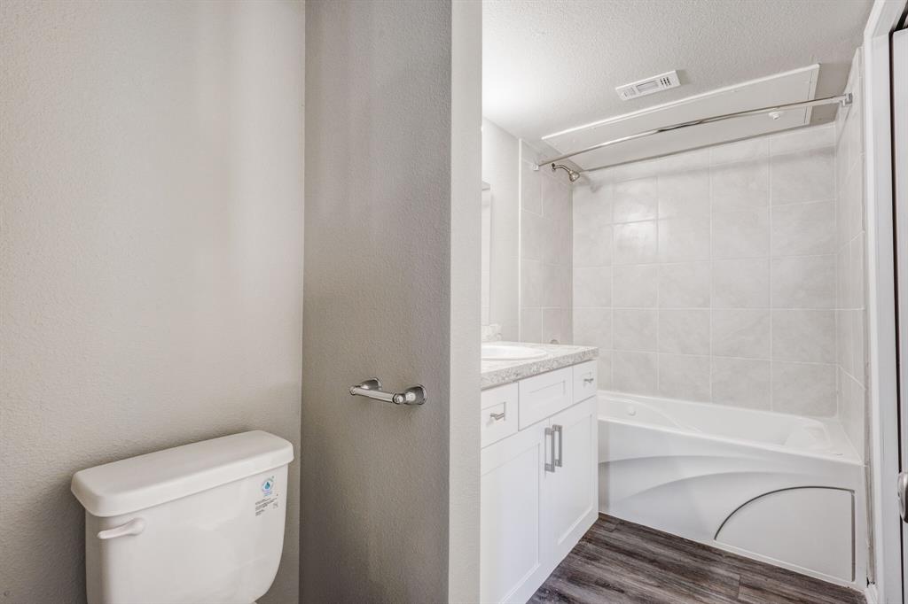 6108 Abrams Road, Unit 503 Dallas, TX 75231 - Photo 12 of 21 a bathroom with a granite countertop bathtub shower and toilet