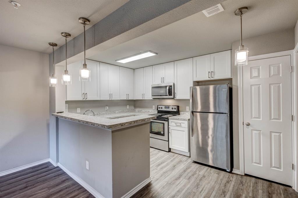 6108 Abrams Road, Unit 503 Dallas, TX 75231 - Photo 14 of 21 a kitchen with refrigerator cabinets and wooden floor