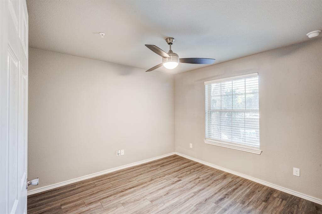 6108 Abrams Road, Unit 503 Dallas, TX 75231 - Photo 6 of 21 an empty room with wooden floor ceiling fan and windows