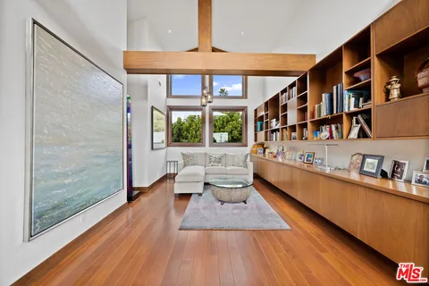 a living room with furniture wooden floor and a book shelf