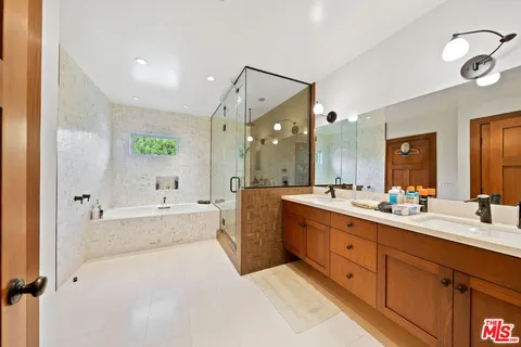 a large bathroom with a double vanity sink large mirror and a bathtub
