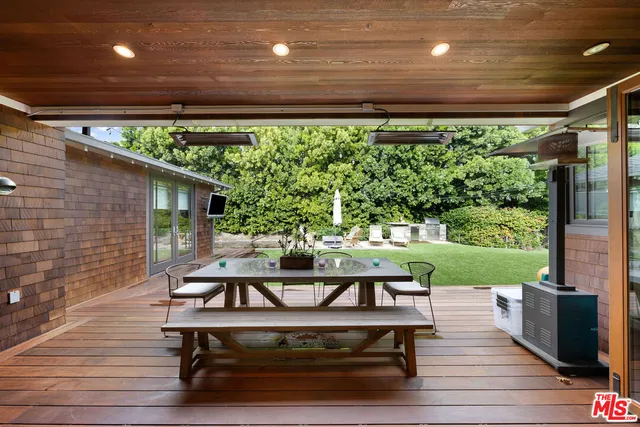 a view of a deck with furniture and garden