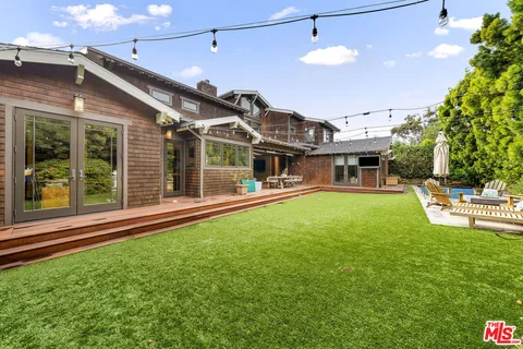 a patio with table and chairs and potted plants