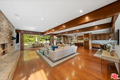 a living room with fireplace furniture and a large window