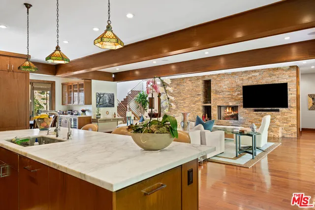 a kitchen with a stove a sink and a living room view