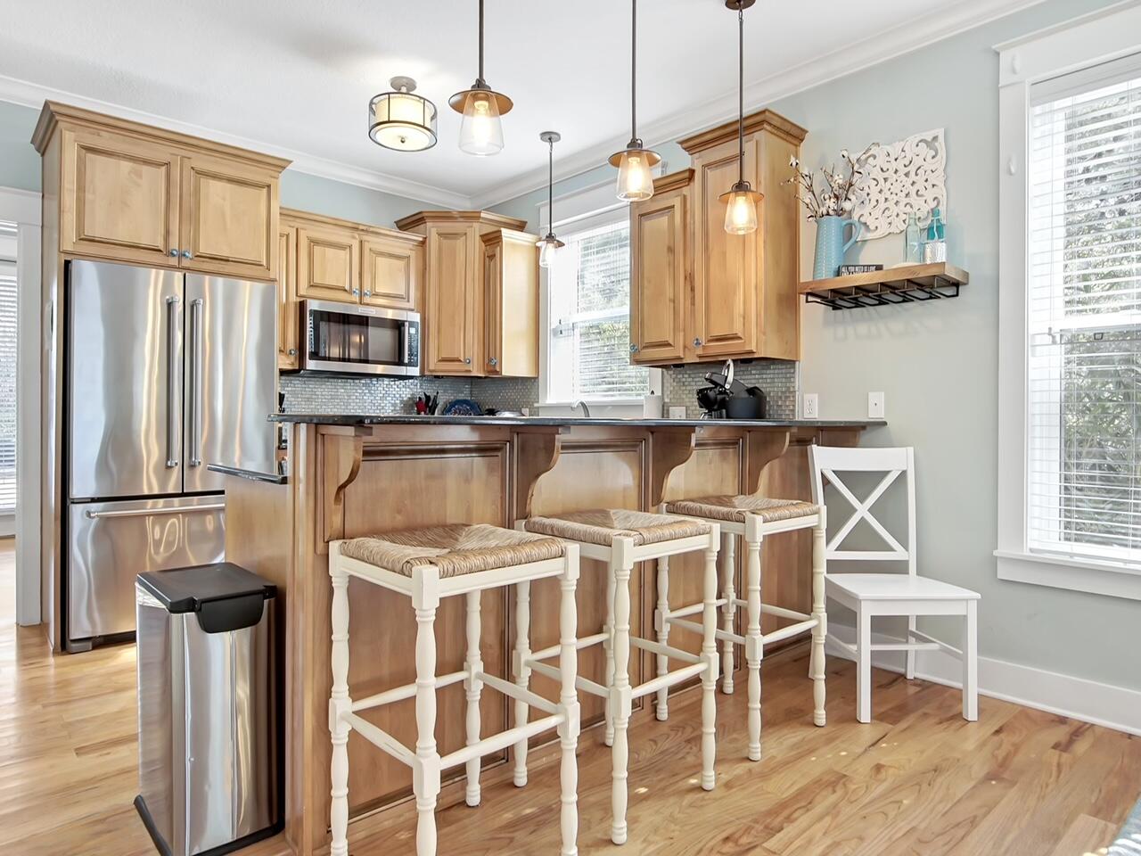212 Seacrest Beach Boulevard East Inlet Beach, FL 32461 - Photo 10 of 39 a kitchen with stainless steel appliances kitchen island granite countertop a refrigerator a stove a oven with white cabinets and wooden floor