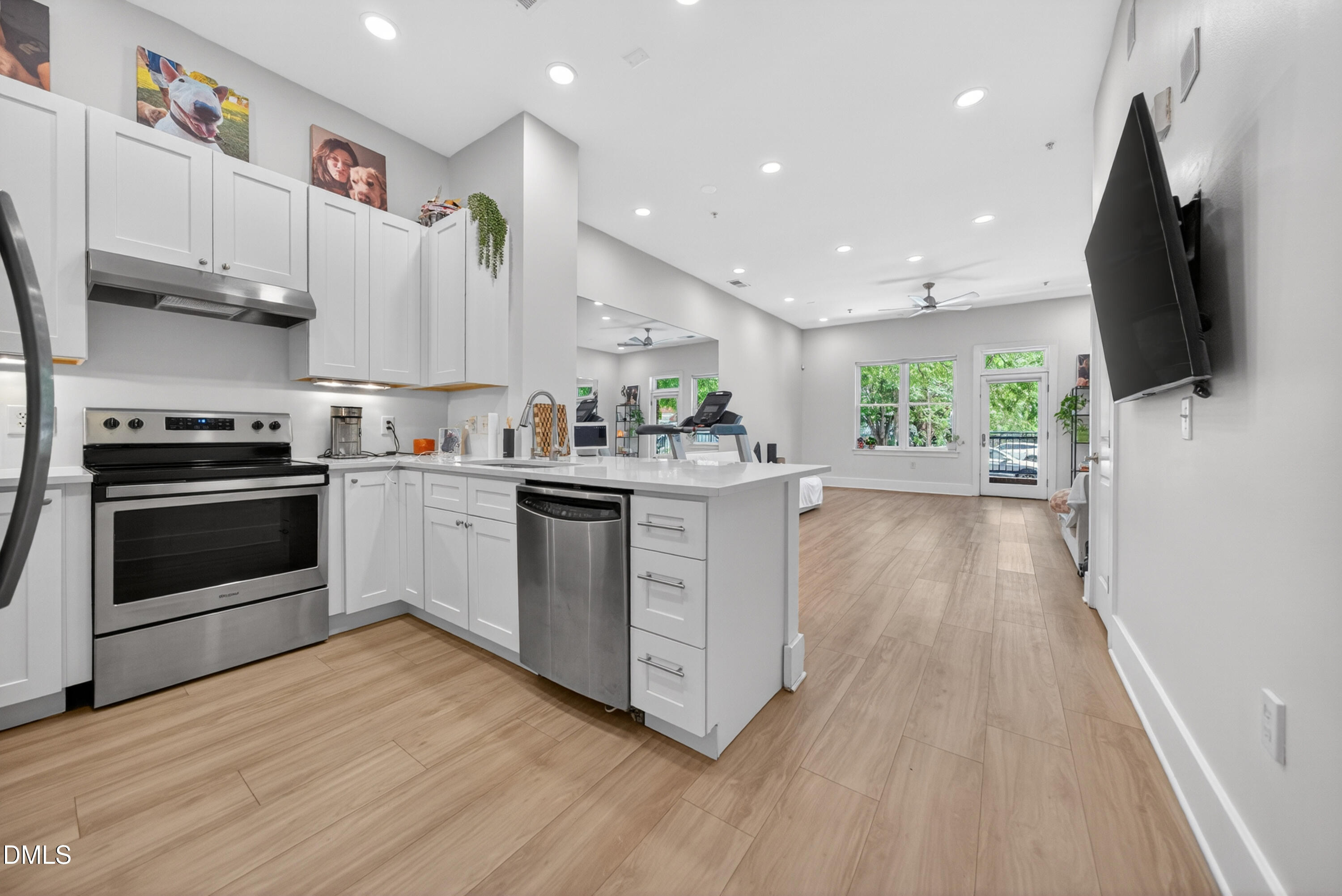 444 South Blount Street, Unit 111 Raleigh, NC 27601 - Photo 23 of 40 a kitchen with stainless steel appliances a stove top oven a sink dishwasher and a refrigerator with wooden floor