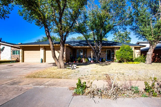a view of a house with a tree in front of it