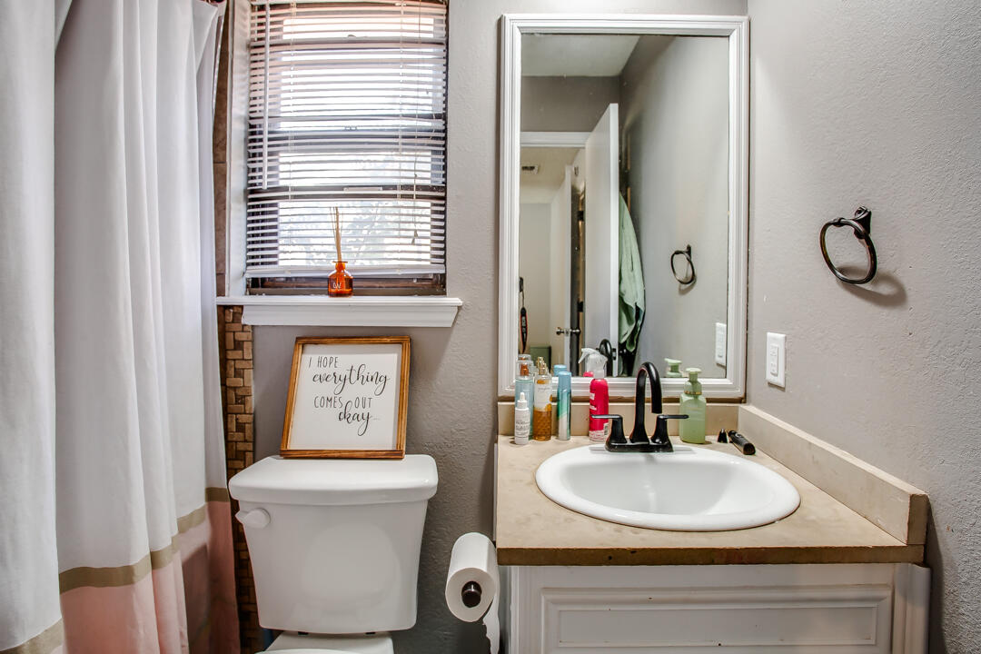 5304 89th Street Lubbock, TX 79424 - Photo 14 of 21 a bathroom with a sink mirror and toilet