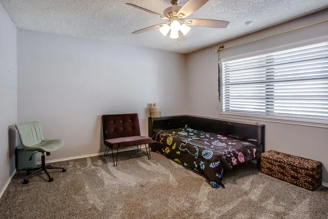 a bedroom with a bed chair and a window
