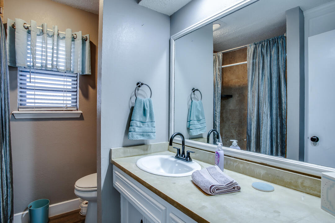 5304 89th Street Lubbock, TX 79424 - Photo 17 of 21 a bathroom with a granite countertop sink toilet and shower