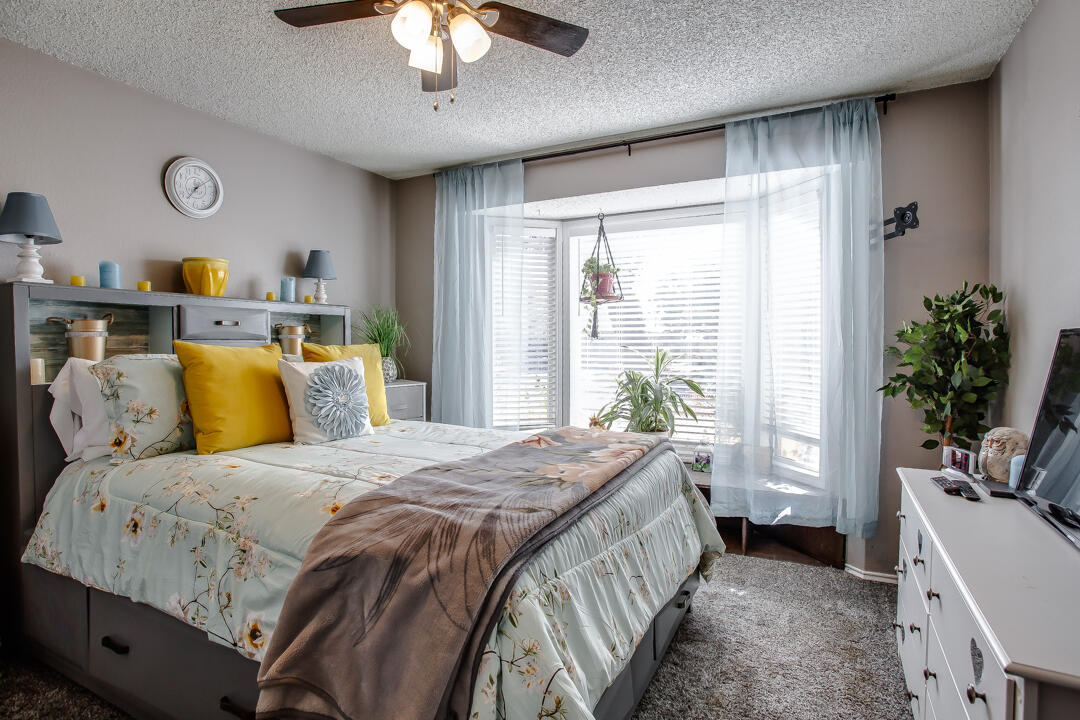5304 89th Street Lubbock, TX 79424 - Photo 18 of 21 a bedroom with a bed and a chandelier