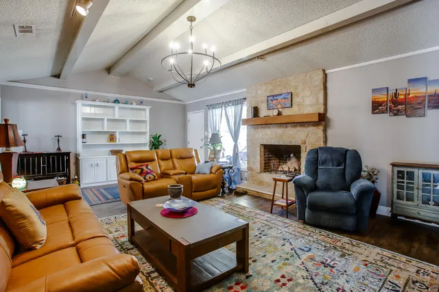 a living room with furniture a fireplace and a chandelier