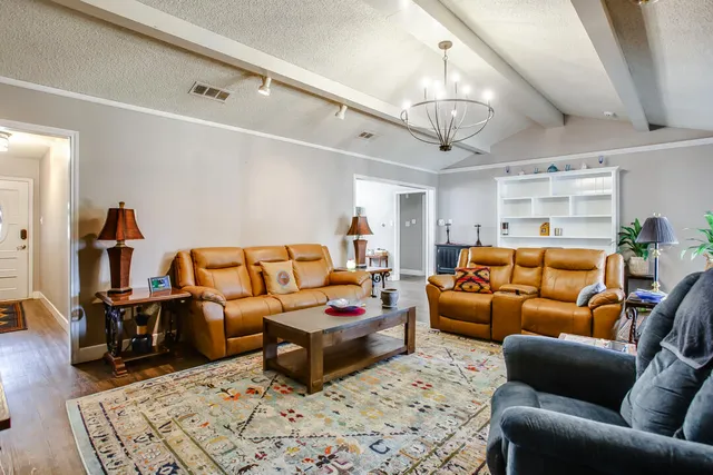 a bedroom with furniture wooden floor and chandelier
