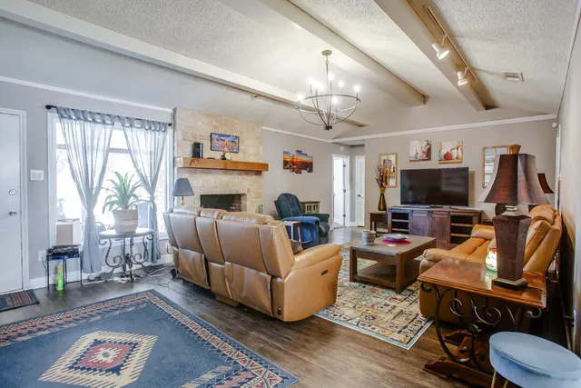 a living room with furniture a flat screen tv and a large window