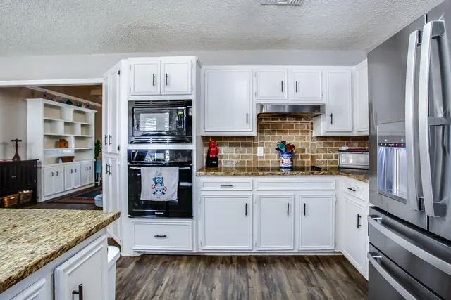a kitchen with stainless steel appliances granite countertop a stove and cabinets