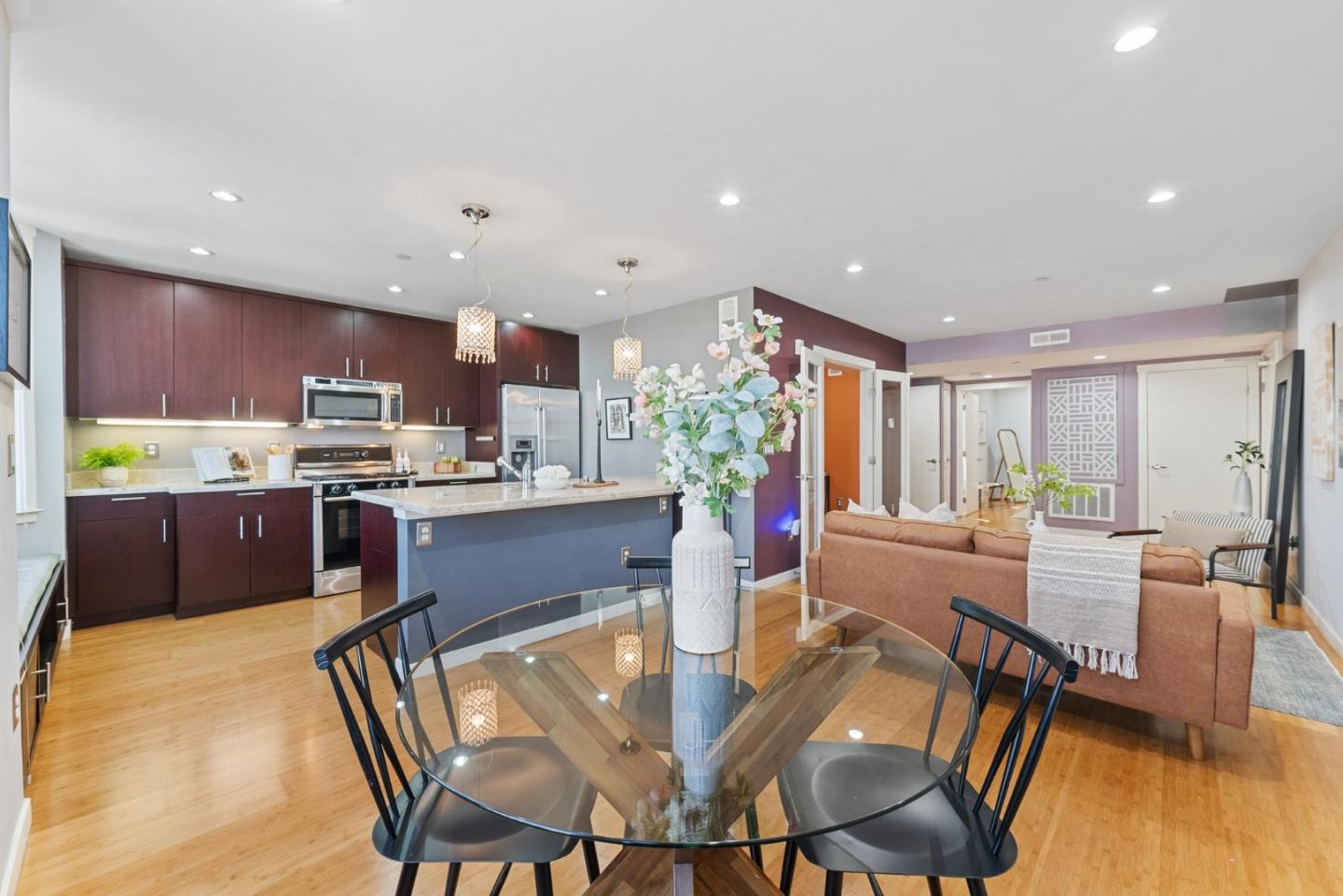 2889 24th Street, Unit 1 San Francisco, CA 94110 - Photo 1 of 1 a kitchen with stainless steel appliances kitchen island granite countertop a dining table chairs and a refrigerator