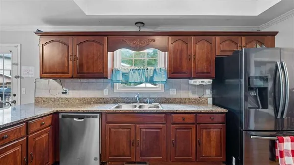 a kitchen with stainless steel appliances granite countertop a refrigerator and a sink