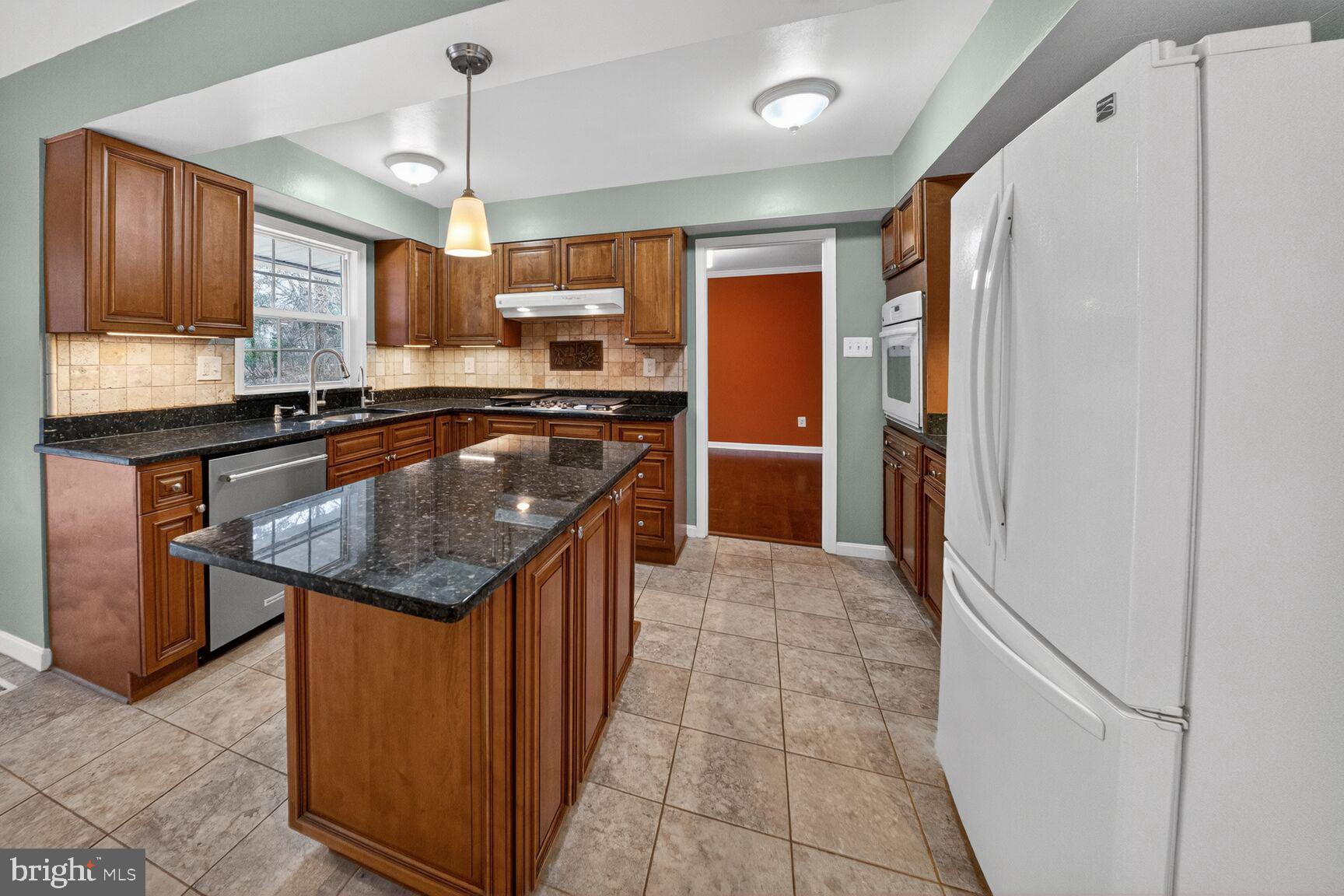 12703 Cedarbrook Lane Laurel, MD 20708 - Photo 12 of 31 a kitchen with stainless steel appliances granite countertop a refrigerator a sink and a stove