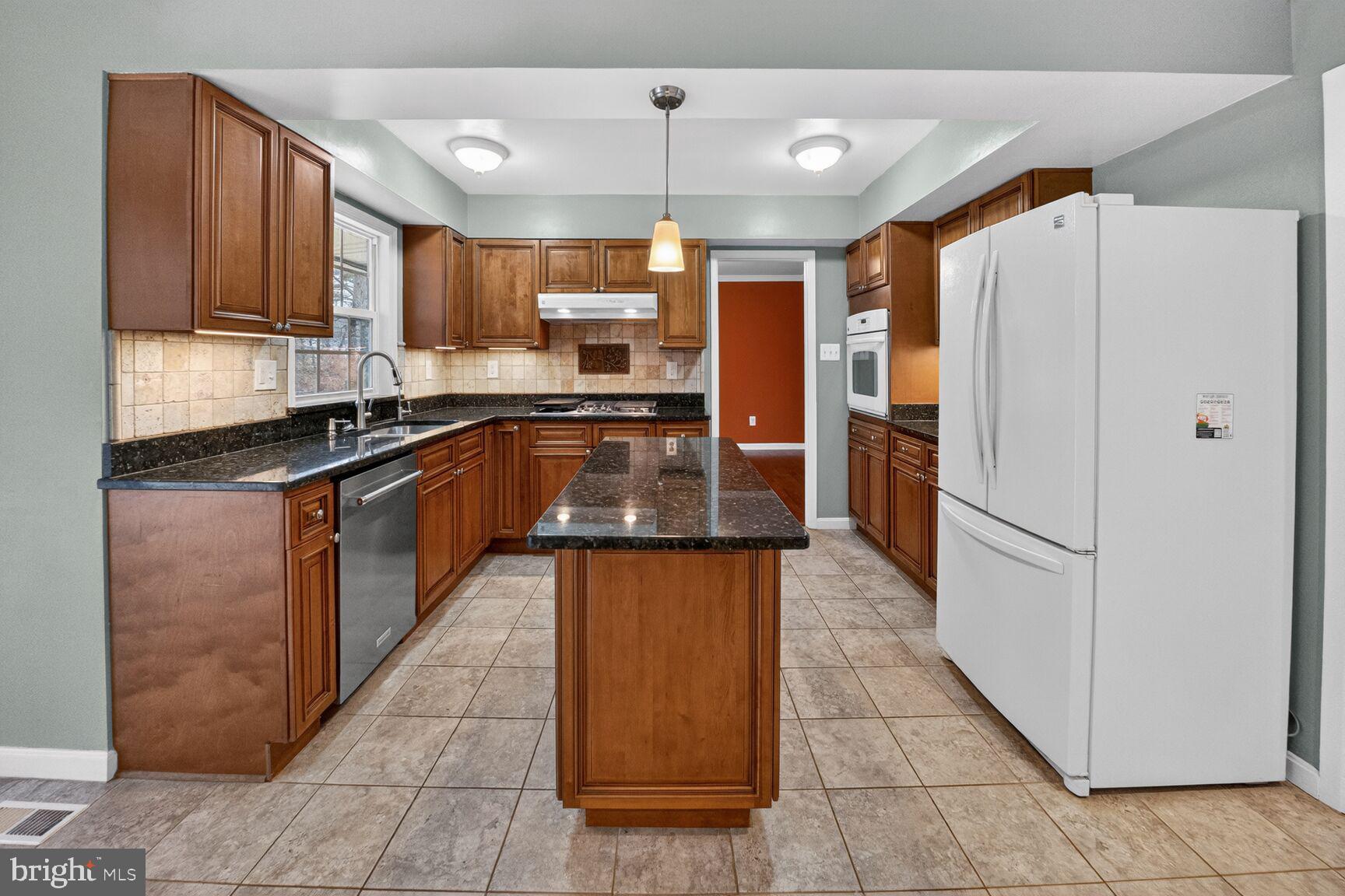 12703 Cedarbrook Lane Laurel, MD 20708 - Photo 7 of 31 a large kitchen with stainless steel appliances granite countertop a refrigerator and a stove
