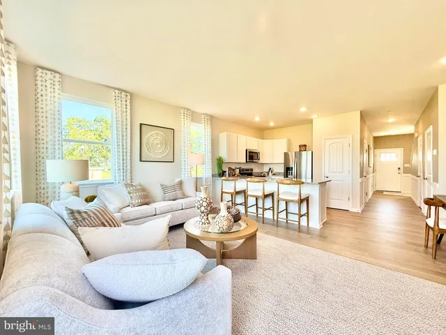 a living room with furniture and a dining table with wooden floor